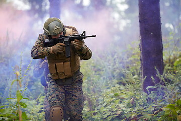 Image showing soldier in action aiming  on weapon  laser sight optics