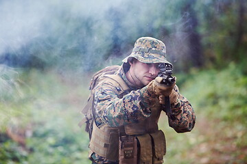 Image showing soldier in action aiming  on weapon  laser sight optics