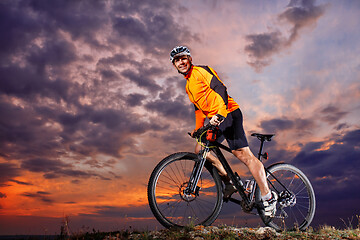 Image showing Man in helmet and glasses stay on the bicycle