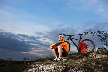 Image showing guy has a rest sitting near his bike