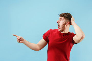 Image showing Isolated on pink young casual man shouting at studio