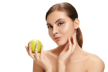 Image showing portrait of attractive caucasian smiling woman isolated on white studio shot eating green apple