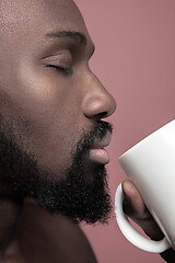 Image showing African man with cup of tea, isolated on pink background