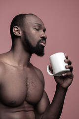 Image showing African man with cup of tea, isolated on pink background