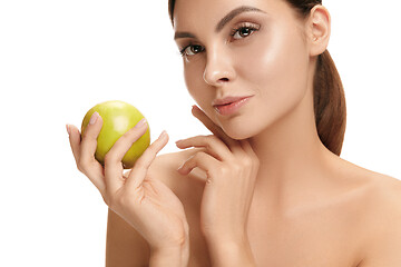 Image showing portrait of attractive caucasian smiling woman isolated on white studio shot eating green apple