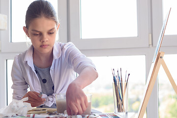 Image showing Girl examines paint in the workplace in the studio