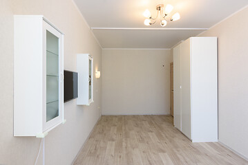 Image showing The interior of the room is under the bedroom, there are cabinets on both sides, a TV is hanging