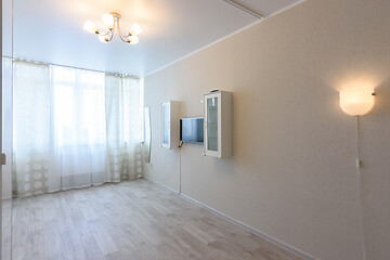 Image showing Fragment of the interior of the room, curtained windows and a wall with a TV and hanging cabinets