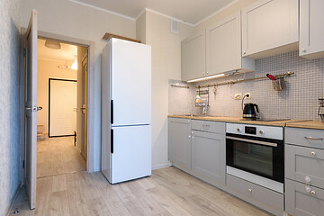 Image showing The interior of a small cozy kitchen in the apartment, the interior door to the kitchen is open