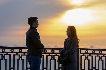 Image showing Young couple by the sea at sunset communicates while respecting social distance