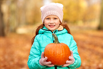 Image showing happy redhead girl with pumpkin at autumn park