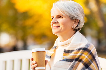 Image showing senior woman drinking coffee in autumn park