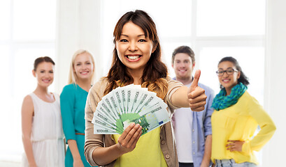 Image showing asian woman with money showing thumbs up