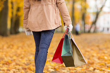 Image showing woman with shopping bags walking along autumn park