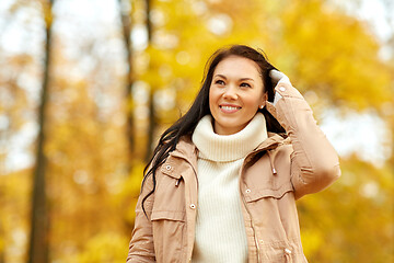 Image showing beautiful happy young woman smiling in autumn park