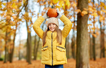 Image showing happy girl with pumpkin at autumn park