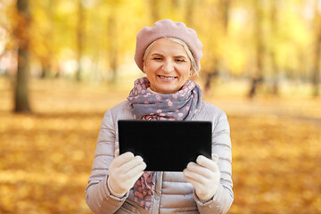 Image showing senior woman with tablet computer at autumn park