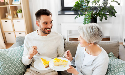 Image showing senior mother and adult son eating cake at home