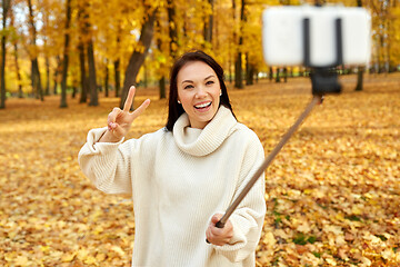 Image showing woman taking selfie by smartphone at autumn park