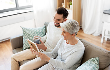 Image showing adult son and senior mother with photo at home