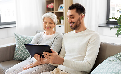 Image showing old mother and adult son with tablet pc at home