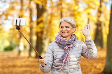 Image showing senior woman taking selfie at autumn park