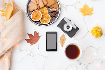 Image showing smartphone, tea, camera, cookies and autumn leaves