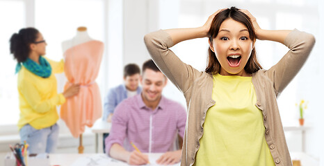 Image showing happy asian woman holding to her head