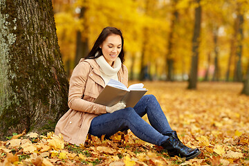 Image showing woman reading book at autumn park