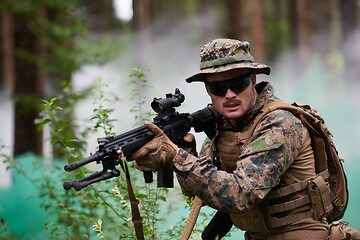 Image showing soldier in action aiming  on weapon  laser sight optics