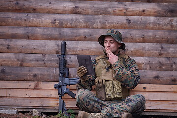 Image showing soldier using tablet computer in military camp