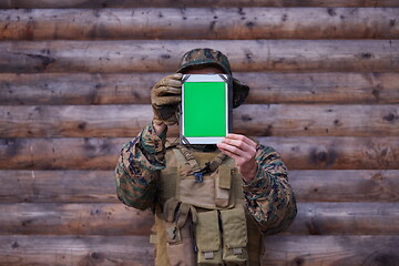 Image showing soldier using tablet computer in military camp