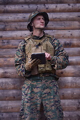 Image showing soldier using tablet computer in military camp