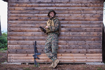 Image showing soldier using tablet computer in military camp