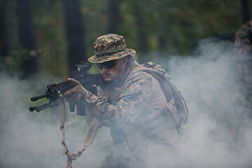 Image showing soldier in action aiming  on weapon  laser sight optics