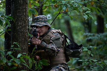 Image showing soldier in action aiming  on weapon  laser sight optics