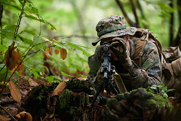 Image showing soldier in action aiming  on weapon  laser sight optics