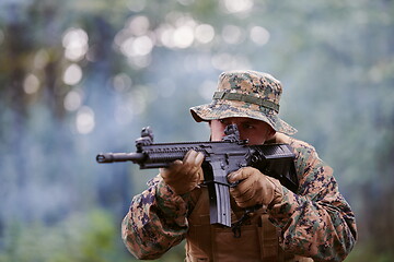 Image showing soldier in action aiming  on weapon  laser sight optics