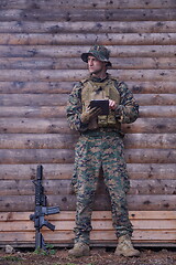 Image showing soldier using tablet computer in military camp