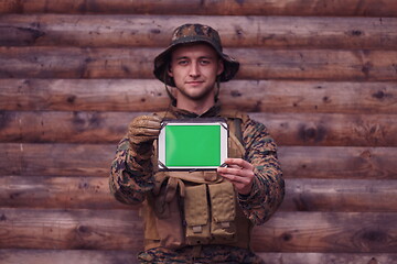 Image showing soldier using tablet computer in military camp