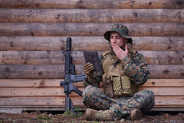 Image showing soldier using tablet computer in military camp