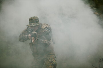 Image showing soldier in action aiming  on weapon  laser sight optics