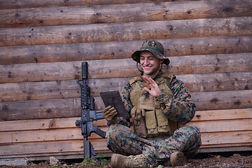 Image showing soldier using tablet computer in military camp