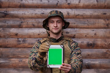 Image showing soldier using tablet computer in military camp