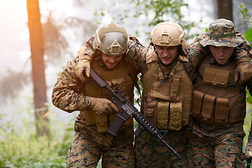 Image showing military squad in action rescue wounded soldier