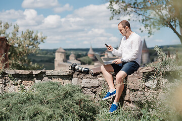 Image showing Handsome businessman with laptop talking on the phone