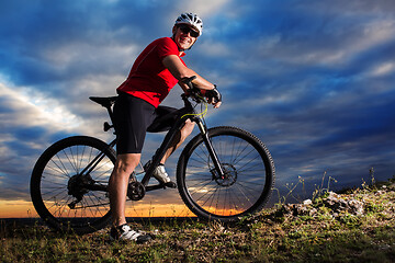 Image showing Cyclist riding mountain bike on trail at evening.