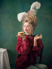 Image showing Young woman as Marie Antoinette on dark background. Retro style, comparison of eras concept.