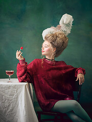 Image showing Young woman as Marie Antoinette on dark background. Retro style, comparison of eras concept.