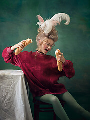 Image showing Young woman as Marie Antoinette on dark background. Retro style, comparison of eras concept.